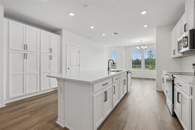 kitchen featuring sink, white cabinetry, wood-type flooring, stainless steel appliances, and a kitchen island with sink