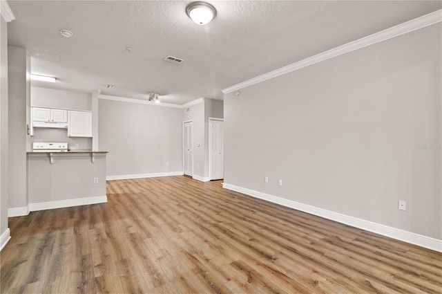 unfurnished living room with light hardwood / wood-style floors, a textured ceiling, and ornamental molding