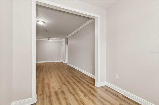 corridor featuring ornamental molding and light hardwood / wood-style flooring