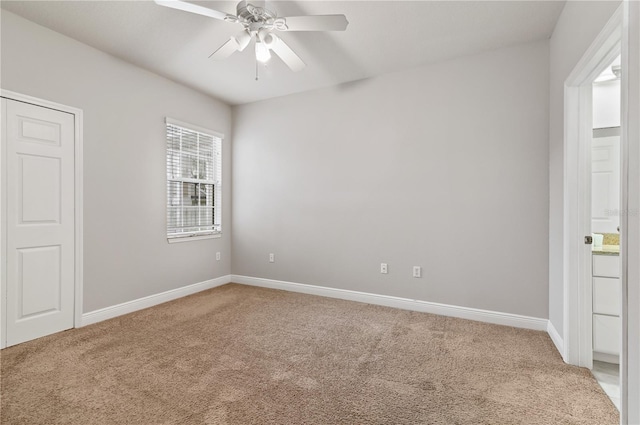 carpeted spare room with ceiling fan