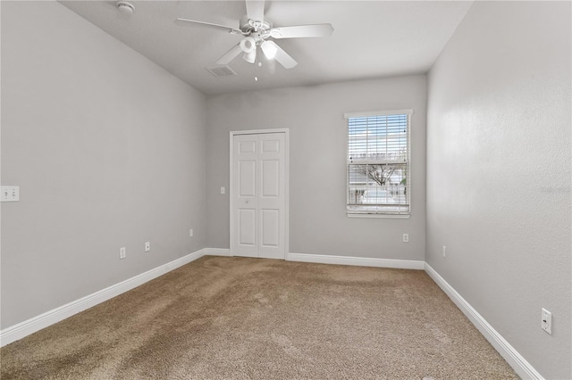 carpeted spare room with ceiling fan