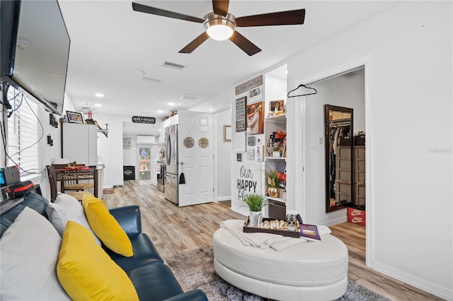 living room featuring ceiling fan and light hardwood / wood-style floors