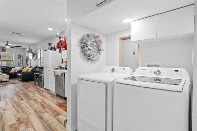 clothes washing area featuring separate washer and dryer, electric panel, ceiling fan, and light hardwood / wood-style flooring