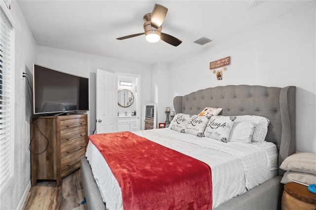 bedroom with hardwood / wood-style floors, sink, ceiling fan, and ensuite bathroom