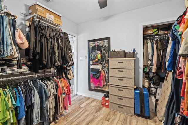 spacious closet with light hardwood / wood-style flooring and ceiling fan