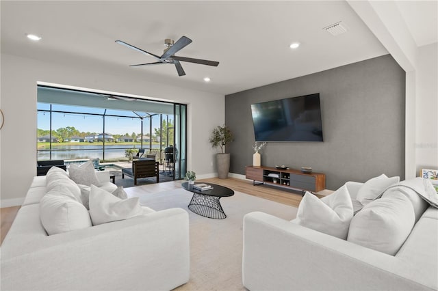 living room with ceiling fan and light hardwood / wood-style flooring