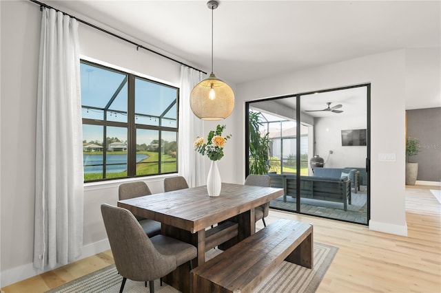 dining area featuring light hardwood / wood-style floors and a water view