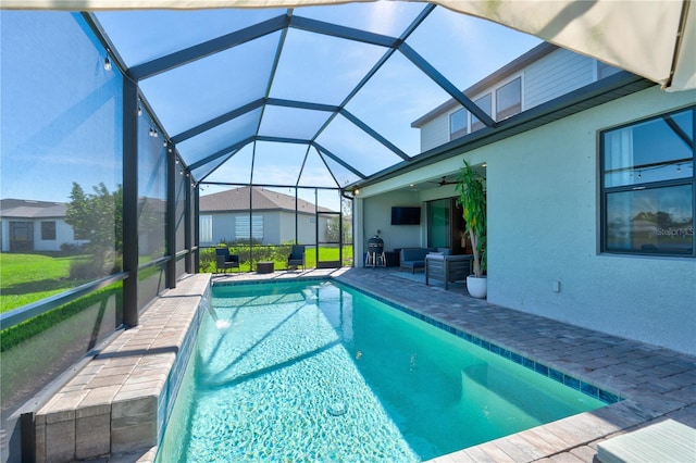 view of swimming pool featuring ceiling fan, glass enclosure, area for grilling, and a patio