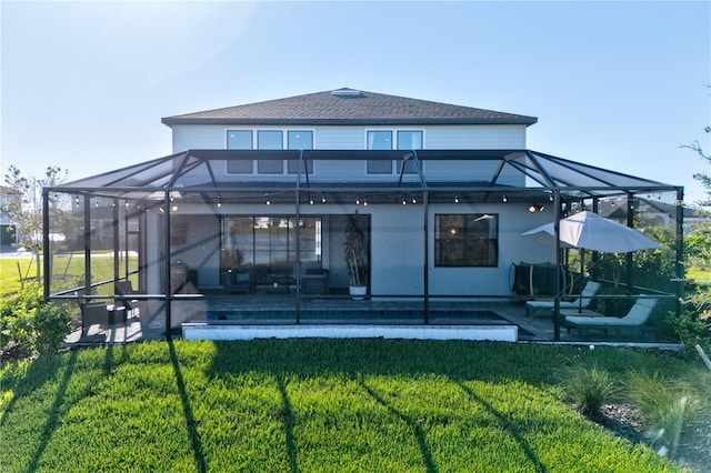 back of house featuring a pool, glass enclosure, a yard, and a patio area