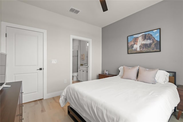 bedroom featuring ceiling fan, light hardwood / wood-style flooring, and ensuite bath