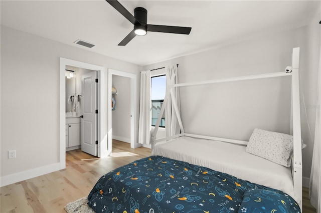 bedroom with ceiling fan, connected bathroom, and light hardwood / wood-style flooring