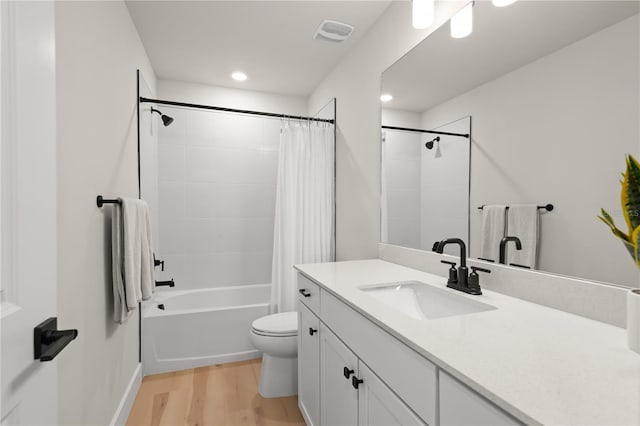 full bathroom featuring vanity, toilet, hardwood / wood-style floors, and shower / tub combo