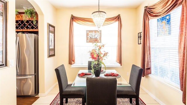 tiled dining room with a chandelier