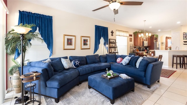 tiled living room featuring ceiling fan with notable chandelier