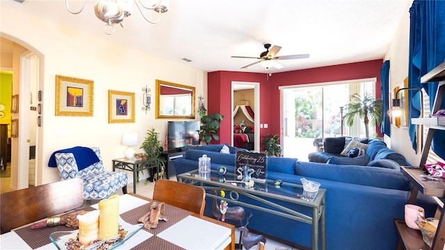 living room featuring ceiling fan with notable chandelier and tile patterned floors