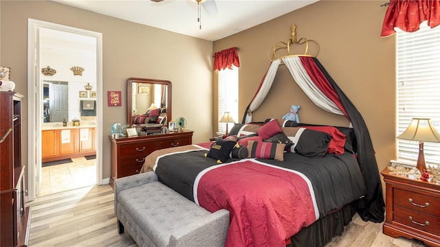 bedroom with ceiling fan, connected bathroom, and light wood-type flooring