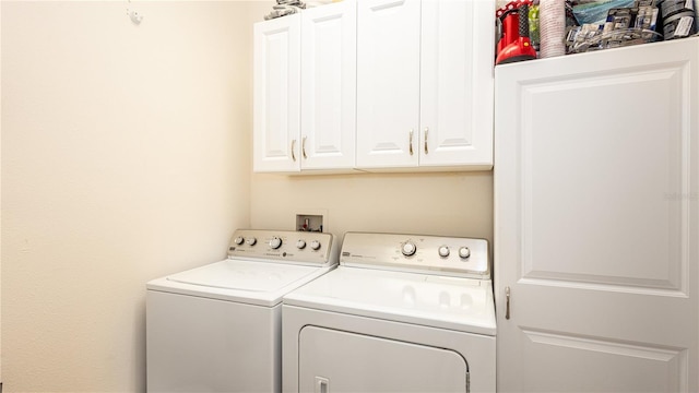 washroom featuring washing machine and dryer and cabinets