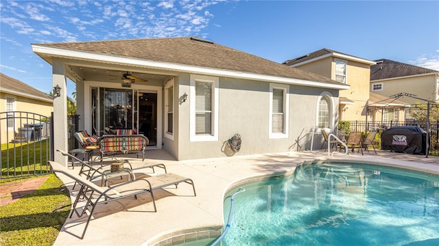 view of swimming pool with ceiling fan and a patio