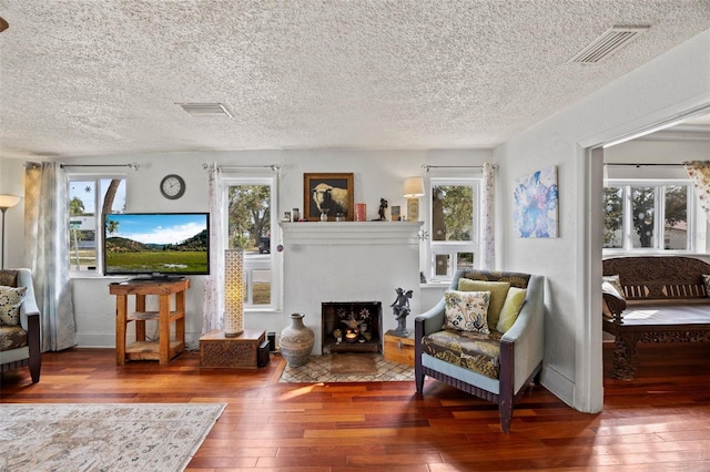 sitting room with a wealth of natural light, hardwood / wood-style floors, and a textured ceiling