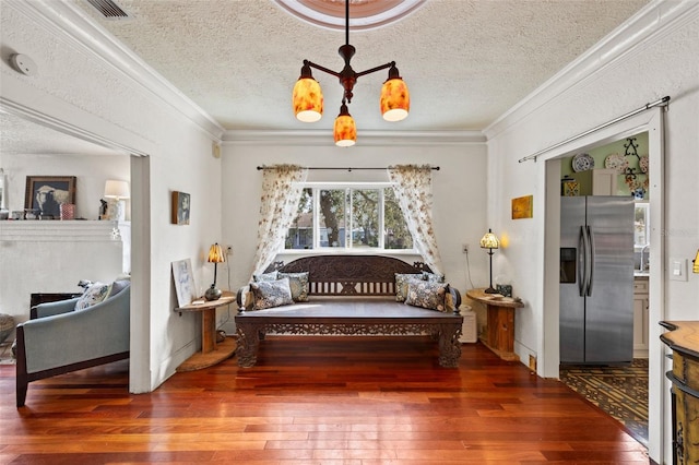 sitting room featuring crown molding, dark hardwood / wood-style floors, and an inviting chandelier