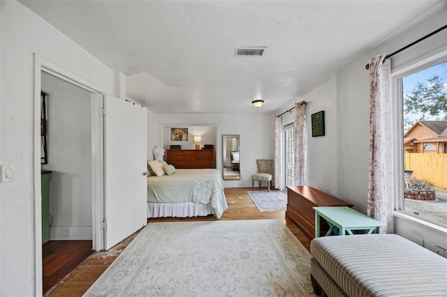 bedroom with hardwood / wood-style flooring and a textured ceiling