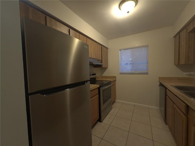 kitchen featuring sink, light tile patterned flooring, and appliances with stainless steel finishes