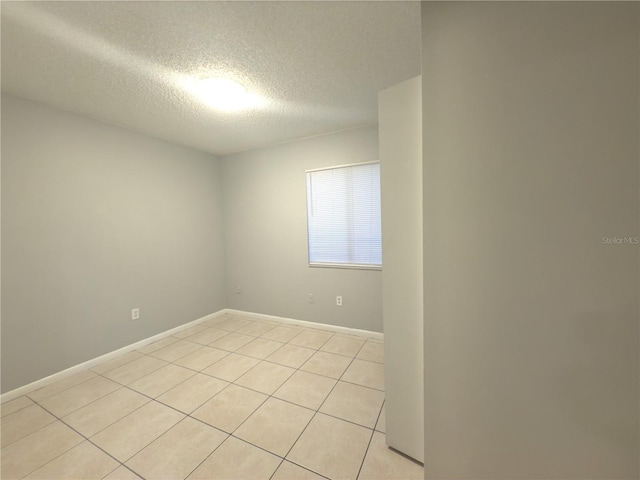 unfurnished room featuring light tile patterned floors and a textured ceiling