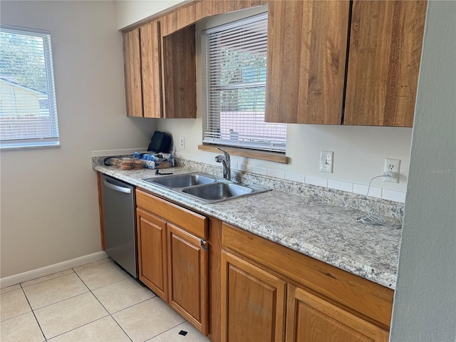 kitchen with dishwasher, sink, light tile patterned flooring, and a healthy amount of sunlight