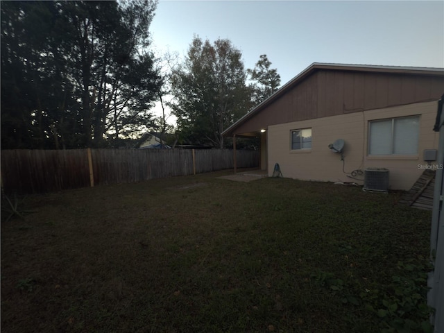 yard at dusk featuring central air condition unit