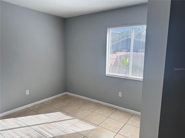 tiled spare room with a textured ceiling