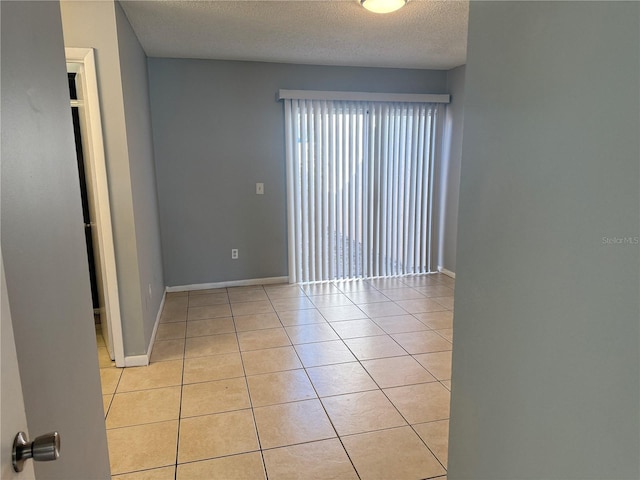 tiled spare room with a textured ceiling