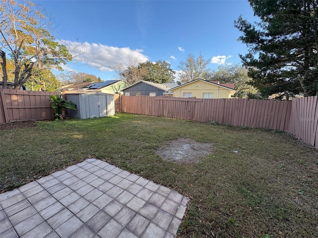 view of yard featuring a storage unit and a patio area