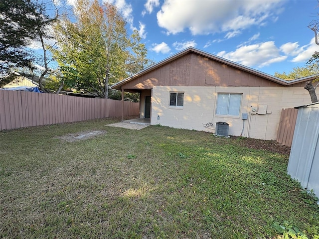 rear view of house with a yard and central air condition unit