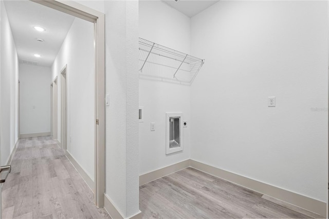 clothes washing area with hookup for an electric dryer and light hardwood / wood-style flooring