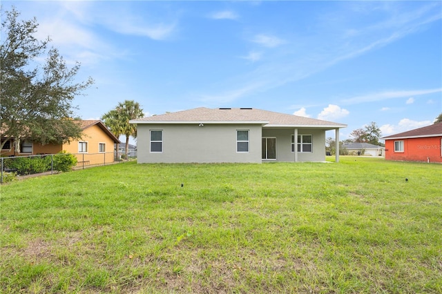 rear view of house featuring a yard