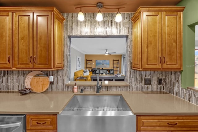 kitchen with rail lighting, sink, hanging light fixtures, ceiling fan, and decorative backsplash