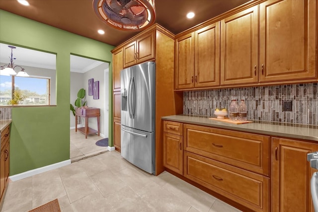 kitchen featuring stainless steel refrigerator with ice dispenser, decorative light fixtures, a chandelier, light tile patterned floors, and decorative backsplash