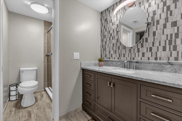 bathroom with vanity, a shower with shower door, and toilet