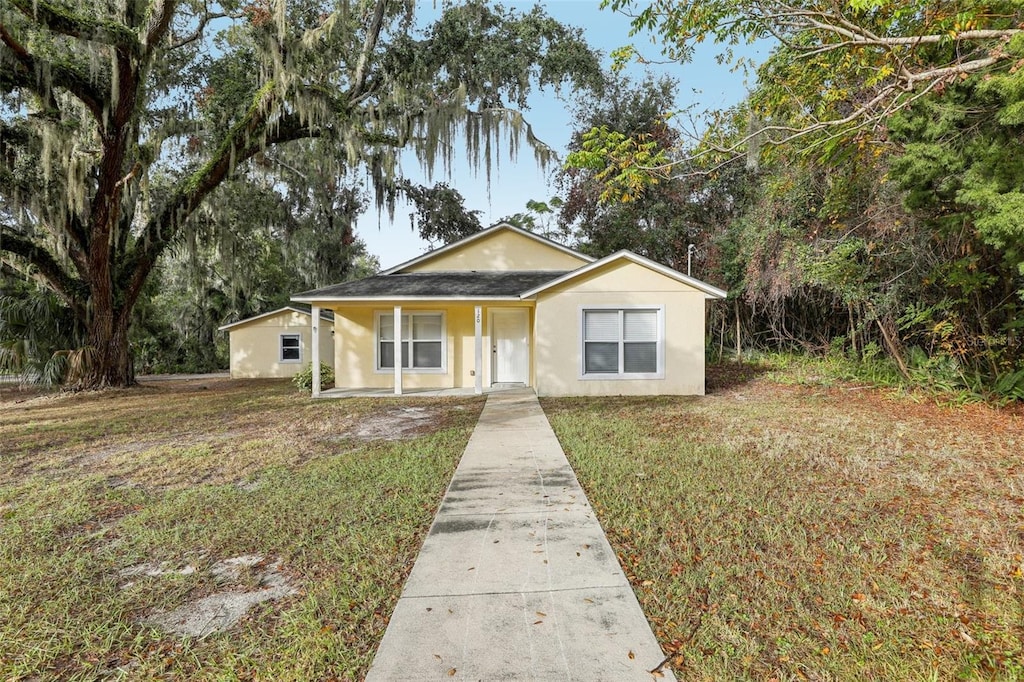 view of front of house featuring covered porch and a front lawn