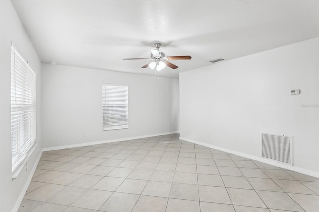 tiled empty room with plenty of natural light and ceiling fan