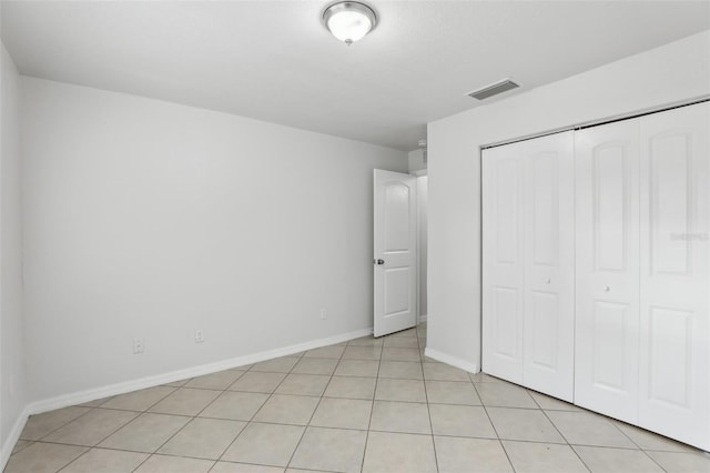 unfurnished bedroom with a closet and light tile patterned floors