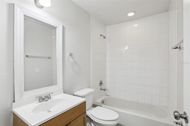 full bathroom with toilet, tiled shower / bath, and vanity