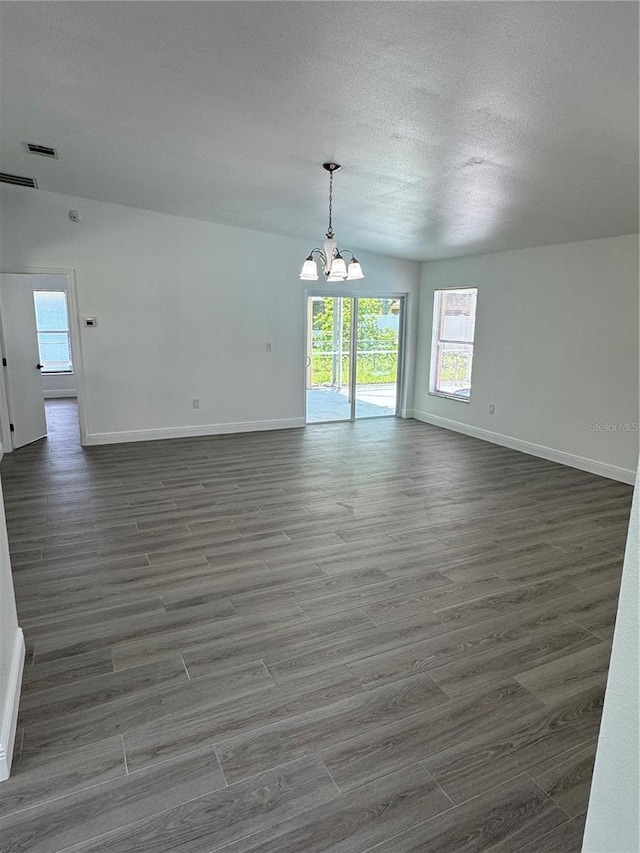 empty room with vaulted ceiling and an inviting chandelier