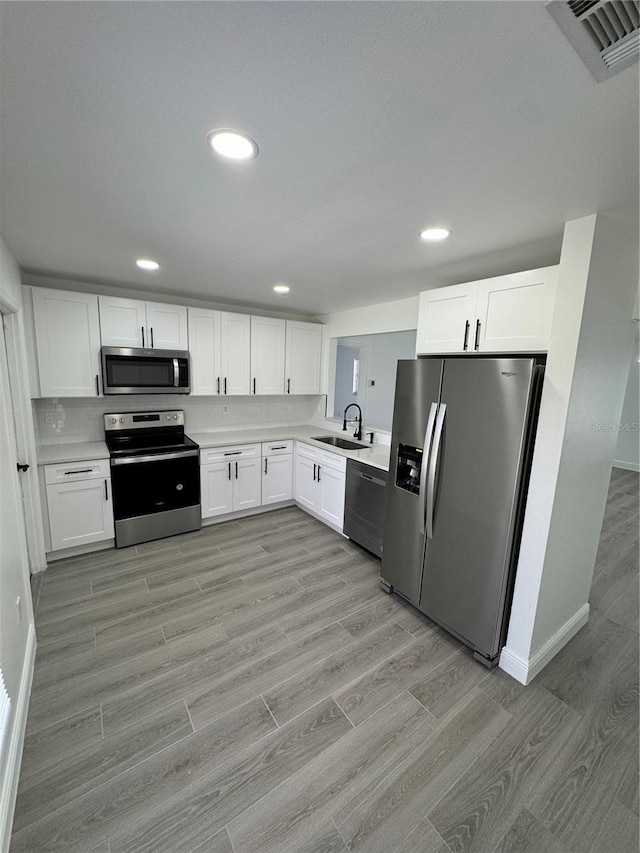 kitchen with sink, white cabinetry, and stainless steel appliances