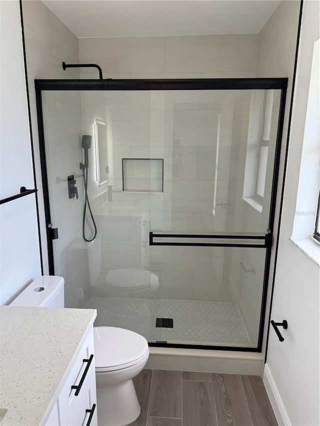 bathroom featuring vanity, toilet, and walk in shower