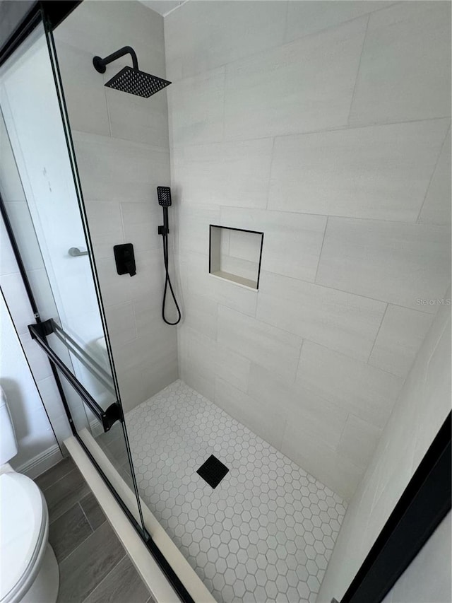 bathroom featuring toilet and tiled shower