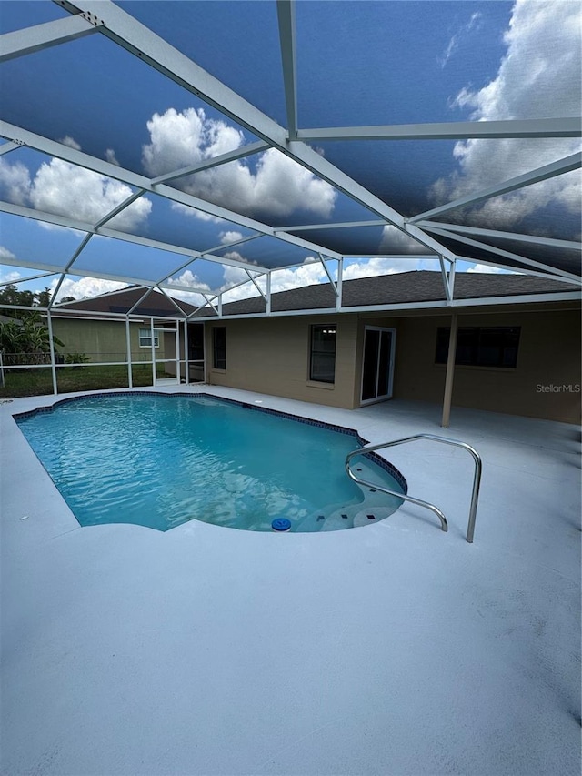 view of swimming pool featuring a patio and glass enclosure