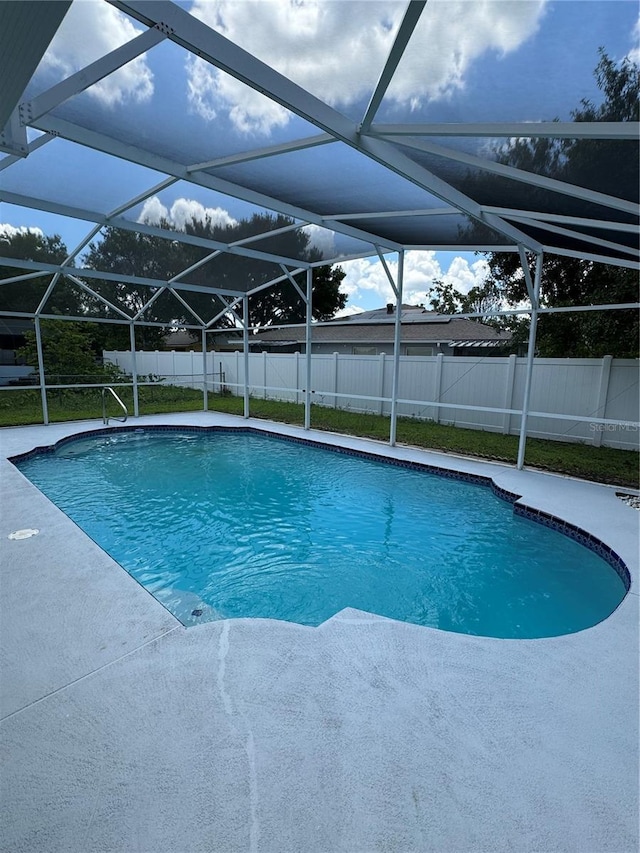 view of swimming pool with a lanai and a patio