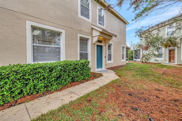 entrance to property featuring a lawn