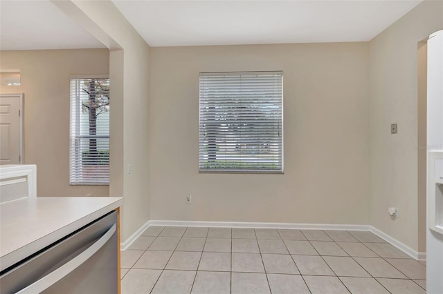 unfurnished dining area with light tile patterned flooring